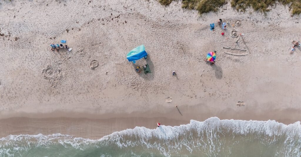 Aerial shot of Fort Pierce beach depicting sand, sea, and beachgoers enjoying a sunny day.